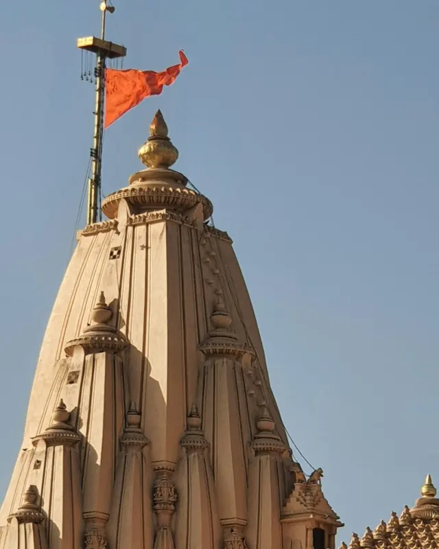 Shikhara and flag of Somnath Temple against a clear sky